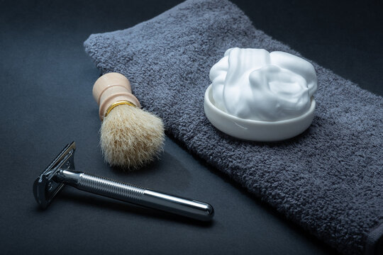 Closeup of men's toilet accessories: a razor, a shaving brush and some shaving foam.