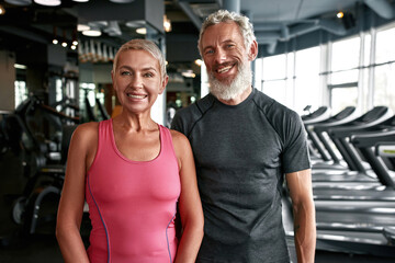 Fototapeta na wymiar Cheerful mature couple at fitness gym
