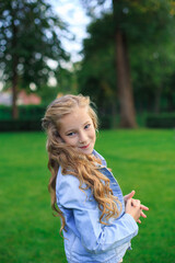 Portrait of a blond, blue-eyed girl in the park