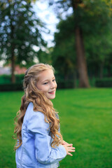 Portrait of a blond, blue-eyed girl in the park