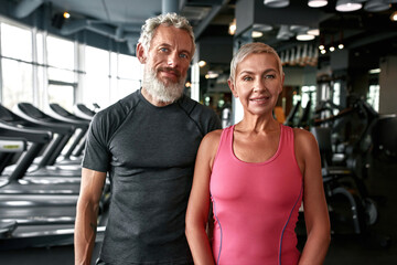 Fototapeta na wymiar Lovely mature woman and handsome man in gym