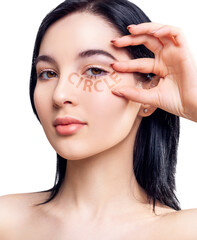 Young brunette woman with circle tag word under eye.