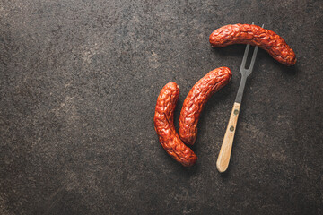 Smoked sausage pricked on a fork.