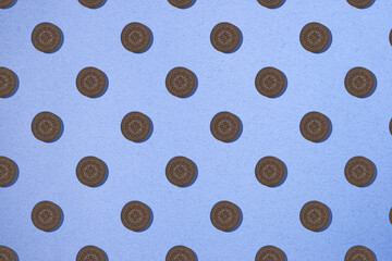 Seamless pattern with brown cookies on a blue background. Minimum isometric texture of food