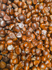 Vertical wallpaper raw hazelnuts display in grocery shop. Brown roasted chestnuts  group background