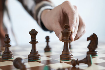 The player moves the king piece, Holds the king chess piece with his hand to make a move. Leisure play at home, leadership skills, strategic thinking
