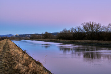 Early evening landscape with waterway shortly after sunset. Beautiful colored sky,  reflection on the surface. Trencin, Slovakia.