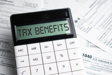 TAX benefits word on calculator. Business and tax concept. Time to pay tax in year. - obrazy, fototapety, plakaty