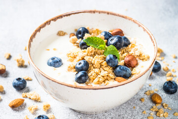 Yogurt with granola and fresh berries at stone table. Healthy food, snack or breakfast.