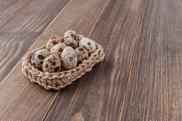 Group of quail eggs are put on clear tray on wooden table.