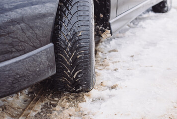 Fototapeta na wymiar Car with winter tires on a snow covered road, winter weather, slippery street, dangerous to drive, cold snowfall