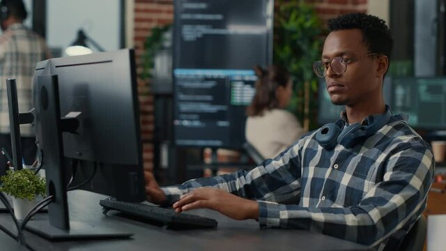 Portrait of software engineer writing code arranging glasses and being happy about parsing results. Smiling programer typing machine learning algorithm on keyboard innovating cyber security.