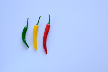 aerial view of three hot peppers on white background