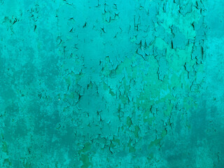 Weathered cyan coloured wall, abstract backdrop, cracked paint on the concrete surface.