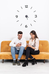 a couple in a waiting room spend their time looking at their phone