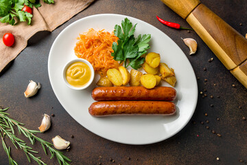Tyrolean sausages with potatoes and fried cabbage top view