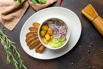 Herring with potatoes on dark brown concrete table top view