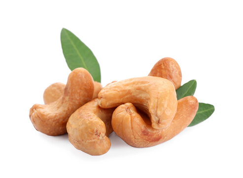 Pile of tasty organic cashew nuts and green leaves isolated on white