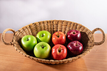 green and red apples in wicker basket