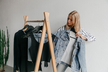 Young woman found a bargain at the store - perfect blue denim jacket for sale