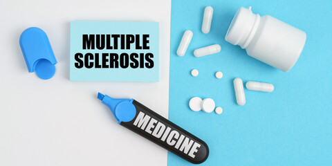 On the white and blue surface are pills, a marker and paper with the inscription - Multiple...