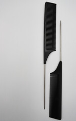a pair of black flat professional black combs meet on a white background