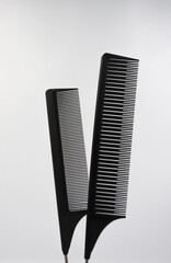 a pair of black flat professional black combs meet on a white background