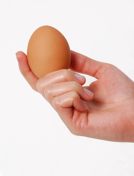 Female hand hold an egg isolated on white background.