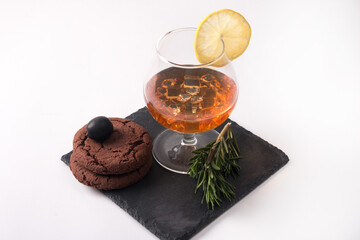 a glass of cognac with lemon. Alcoholic drink on a white background
