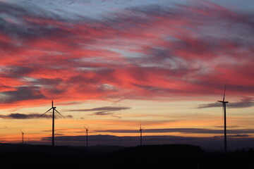 Fototapeta na wymiar Windpark in der Nacht. Roter Himmel bei Sonnenuntergang.
