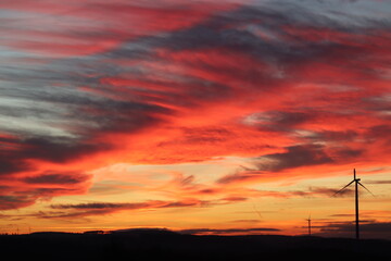 Windpark in der Nacht. Roter Himmel bei Sonnenuntergang.