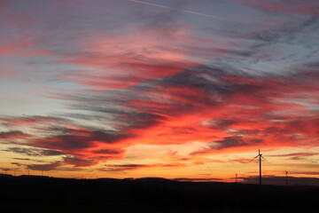 Windpark in der Nacht. Roter Himmel bei Sonnenuntergang.
