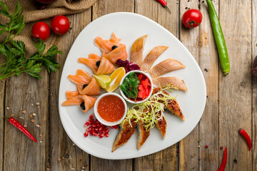 different fish slicing on a plate on wooden table top view