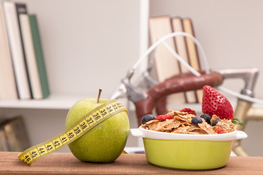 apple with tape measure and cereals at home with bicycle