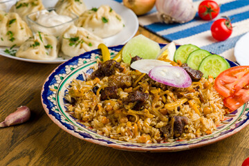 pilaf with beef, manty with beef and salad on wooden table