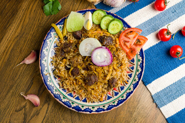 pilaf with beef and salad on wooden table top view