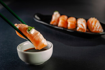 Blowtorcherd salmon onigiri on chopsticks.