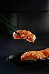 Truffle salmon onigiri on chopsticks.