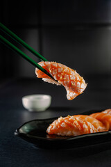 Truffle salmon onigiri on chopsticks.