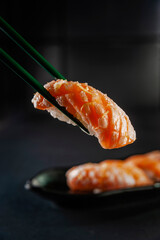 Truffle salmon onigiri on chopsticks.