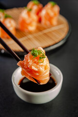 Salmon Jhow sushi on chopsticks.