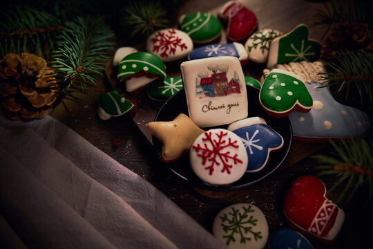 Candy board decorated with gingerbread cookies, Christmas tree branches and pine cones on wooden board