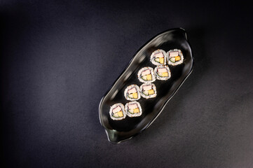 Uramaki with cucumber, mango fruit and crab sticks.