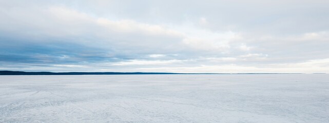 Frozen forest lake on a cloudy day. Dramatic sky after a blizzard. Onega, Karelia,...