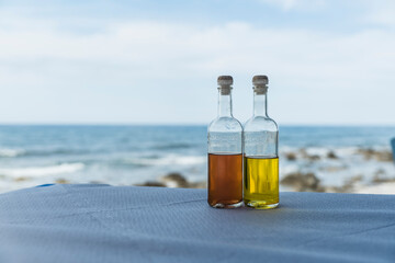 zwei Flaschen Olivenöl auf Tisch einer Taverne am Meer in Griechenland