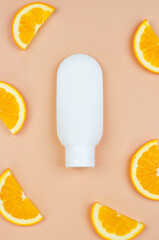 White tube and orange, top view. Mockup for advertising cosmetics with vitamin C. Mockup of cosmetic brand for moisturizer, lotion, foam or shampoo