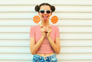 Summer portrait of happy smiling young woman with lollipop on white background