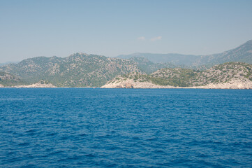 Fototapeta premium Blue sea and mountain under sky. Landscape background on sunny afternoon