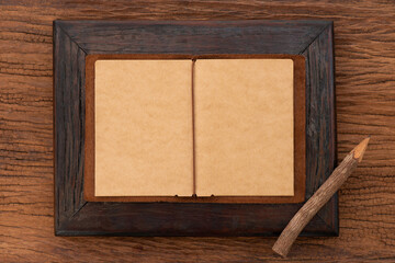 Paper on wood frame and pencil on an old wood.top view.