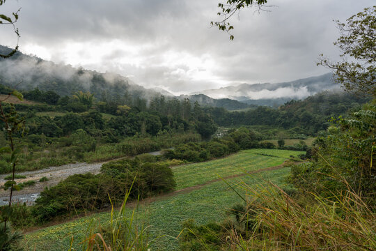 Dramatic image of agricultural fields and farms along a river high in the Caribbean mountains of the Dominican Republic.landscape, early morning cloudy skies.